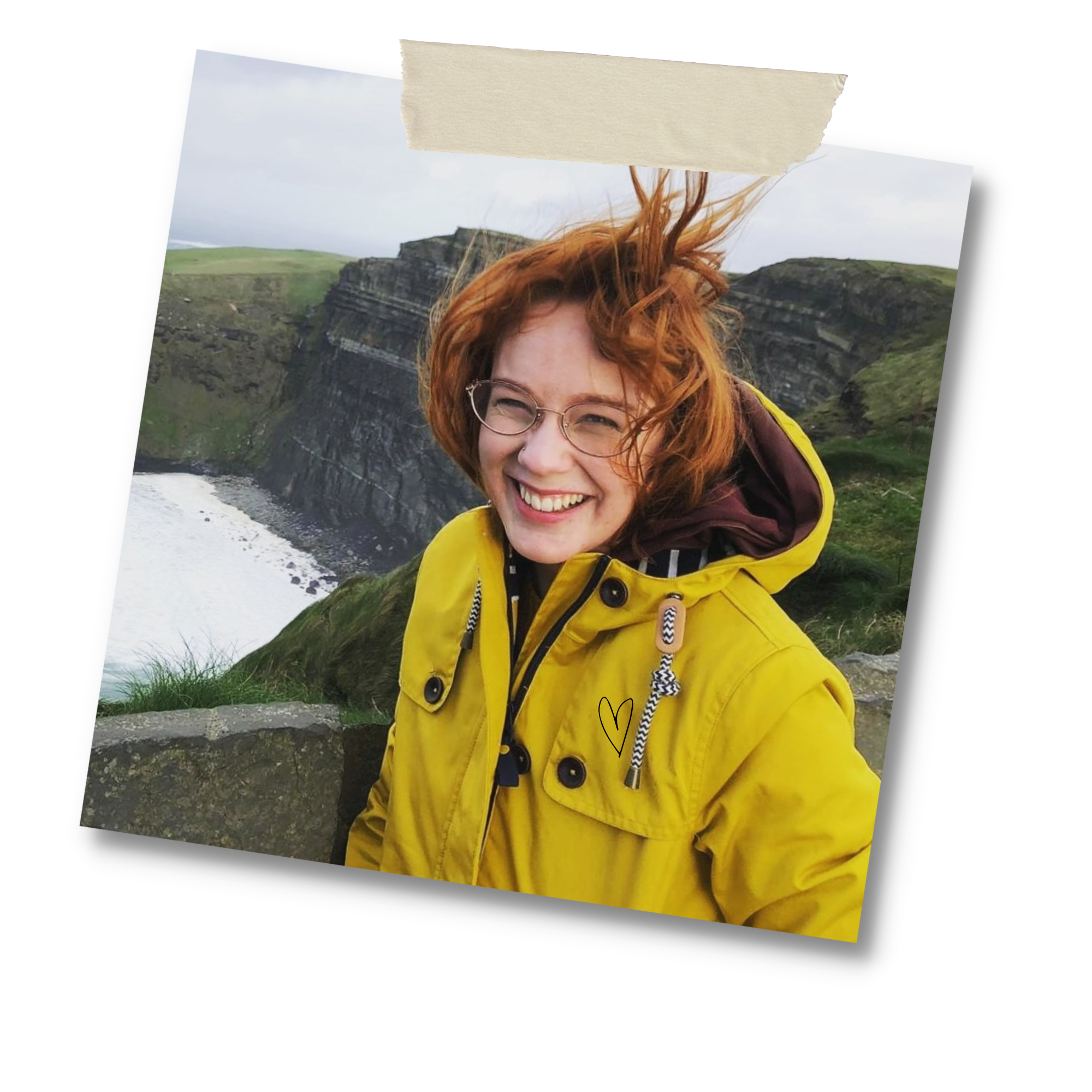 Alyssa in a yellow raincoat at some sea cliffs in Ireland